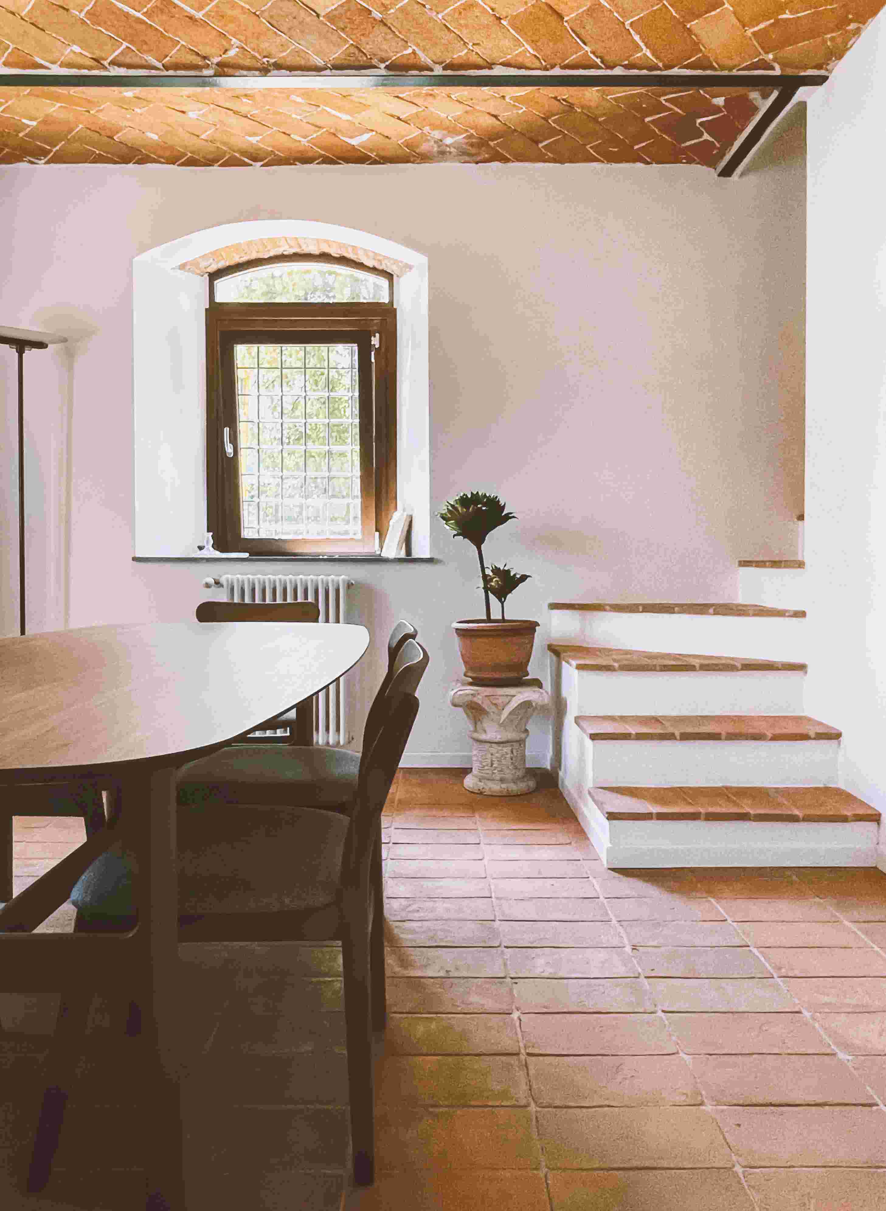 Dining area — cotto floor, brick ceiling vault, heritage staircase
