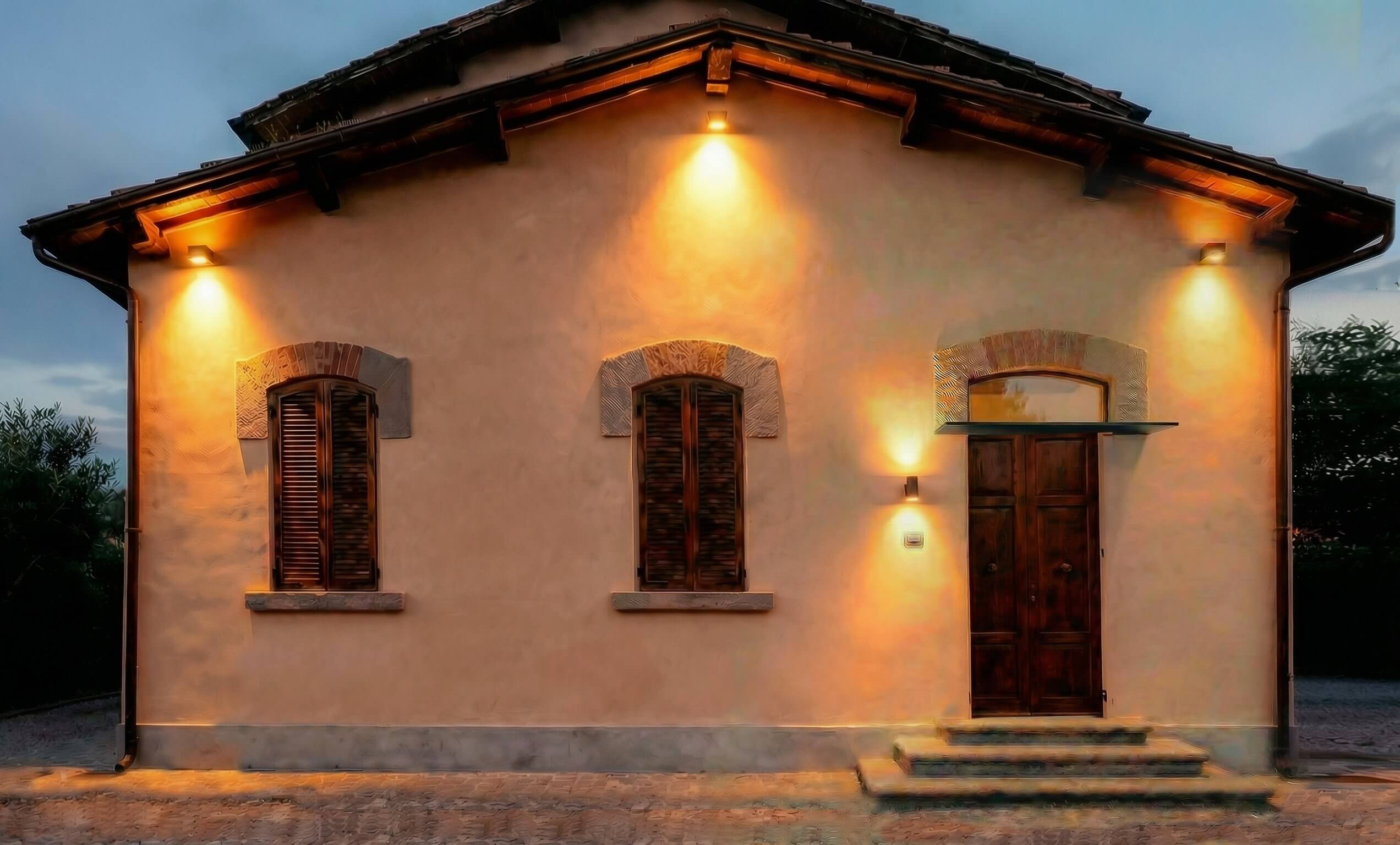 Restored farmhouse at dusk — exterior lighting