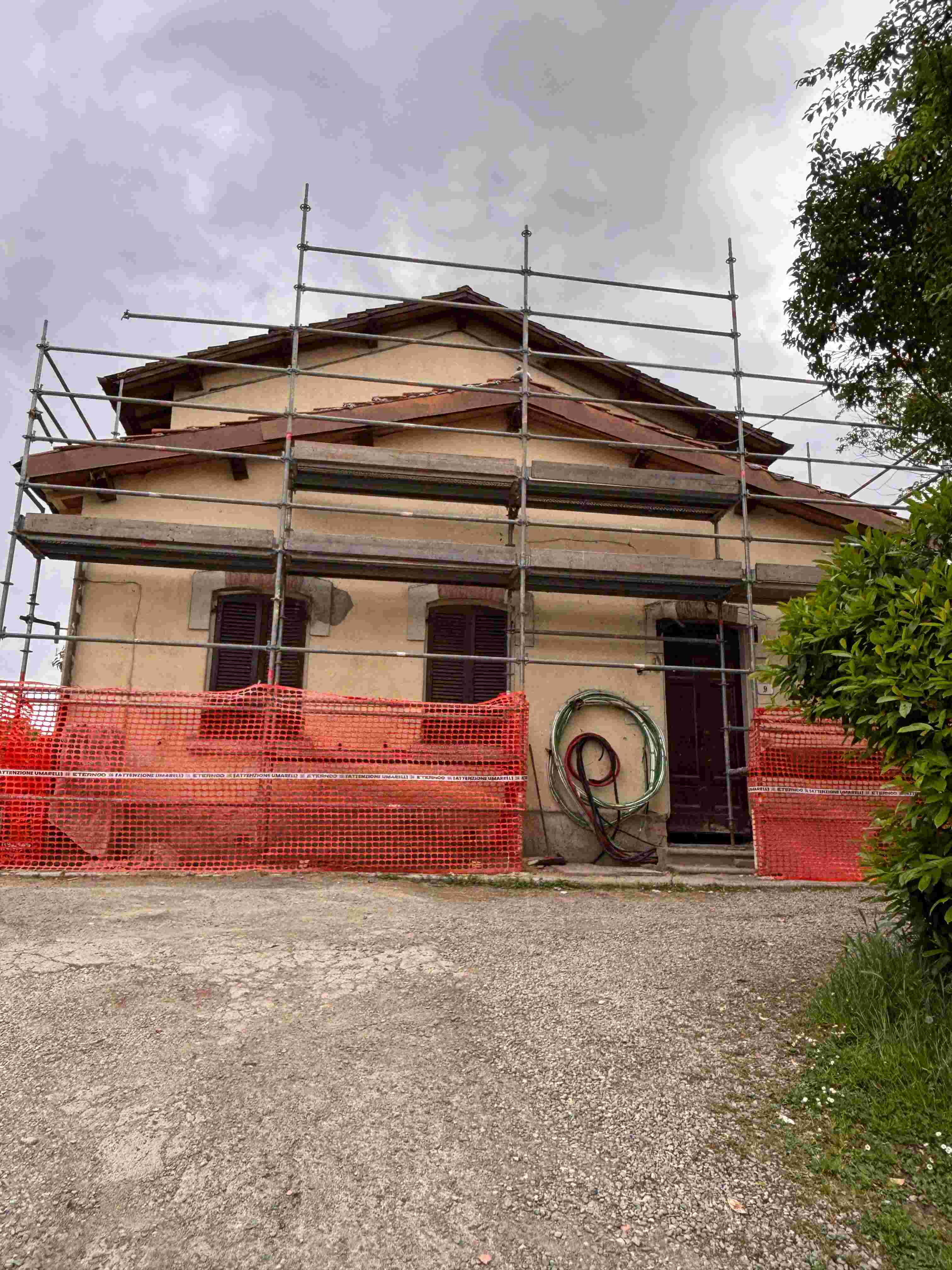 Heritage farmhouse under restoration — scaffolding and roof work
